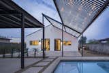 Large expansive steel shade trellis with bistro lighting just off the pool