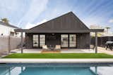 Rear exterior modern design with covered patio area, pool and double doors from master suite and kitchen. 