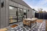 Unique exterior textures with a steel door ideal for outdoor-indoor living and concrete tile patio. 