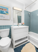 Renovated bathroom featuring penny tile floors and maintaining the original design elements from the 70's.