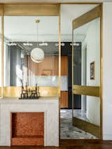 Brass-framed partition designed by Blockstudio; ceiling lamp, Lee Broom, statuette by Igor Shelkovsky, Alina Pinsky Gallery.