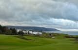 The houses exist at the edge of the land and sea, with the town of Inverness and highlands beyond