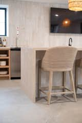 Waterfall edge with custom countertop; concrete flooring.