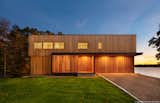 Exterior, Beach House Building Type, Wood Siding Material, Metal Roof Material, and Flat RoofLine Cedar slats create privacy for the windows and front entry. The flush garage door disappears into the facade  Photo 1 of 14 in Westport River Retreat by Mark Lawton