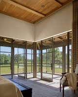 The master bedroom features a large corner window and door unit, and a corner screened porch.