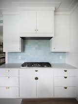 Range and kitchen cabinets with blue ceramic tile.