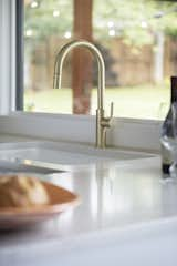 Kitchen, Undermount Sink, Ceramic Tile Backsplashe, White Cabinet, Range, Engineered Quartz Counter, Medium Hardwood Floor, and Ceiling Lighting Gold finished kitchen hardware  Photo 18 of 57 in Cottingham Home by Tommy Daspit