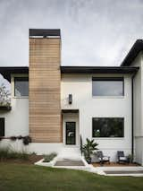 Entrance and rough wood siding chimney.