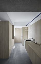 From the main door, the space transitions fluidly to the shower area as seen, with no physical partitions. This is possible by using a solid phenolic version of the same laminate used for the rest of the home's cabinetry in the wet area.