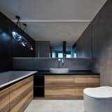 Bath Room, Stone Counter, One Piece Toilet, Alcove Tub, Concrete Wall, Concrete Floor, Ceiling Lighting, and Vessel Sink Bathroom  Photo 7 of 19 in Techno Lover Apartment by Perspektiv