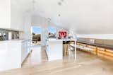 A PURE WHITE HIGH GLOSS KITCHEN EXPERIENCE OF CUSTOM CABINETRY, CUSTOM DINING COUNTERTOP & CUSTOM CUSHIONED BENCH SEATING.