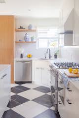 Fully renovated galley kitchen with large checker patterned floors, a nod the original 1950s home.
