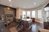Beautiful home office with leather flooring & a fireplace walks out to a lower patio.
