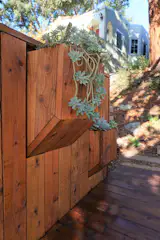 The fencing around the waste enclosure folds out and up to form tiered planters.