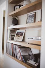 Custom oak open shelving inset in the living room provides the perfect spot for music, books and family moments. 