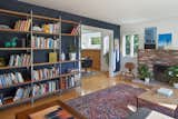 The living room’s steel-framed bookcase, with cherry shelves, is a custom design by the architect. “The floor was so uneven, I knew the feet had to be adjustable,” says Rudabeh. The wall behind them is painted in Benjamin Moore’s Hale Navy, and the other walls are painted in Benjamin Moore’s Chantilly Lace. The popcorn was scraped off the ceiling and replaced with a thin coat of plaster.