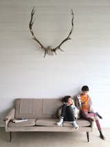 In the porch room, Max, 10; and Emily, 8, sit on a vintage sofa from Gone Vintage in Belleville, Ontario. The caribou antlers are from Aberfoyle Antique Market in Puslinch, Ontario.