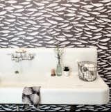 The combined laundry room/powder room features Sardines Charcoal wallpaper by local artist Kate Golding.