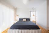 The primary bedroom has a view of the backyard to the left. The lighting over the nightstands are Henry pendants from West Elm; the large pendant light is the Glo-Ball from FLOS.