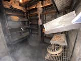 Root cellar was blasted from solid granite. Recycled catwalks make up the shelving and snow fence for wall coverings and storage boxes.