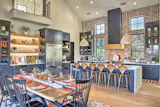 The kitchen is a mixture of natural wood elements. The space was designed for large family get togethers and entertaining in mind. The brick wall was an homage to the couples original city, St. Louis.