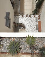 Concrete handmade tiles on first level terrace and white gravel on courtyard.