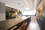 Kitchen, Engineered Quartz Counter, Track Lighting, Pendant Lighting, Laminate Cabinet, Undermount Sink, Wine Cooler, Medium Hardwood Floor, Beverage Center, Recessed Lighting, and Cooktops  Photo 13 of 25 in Modern, cozy and elegant apartment with large windows by Sincro