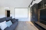 Living Room, Track Lighting, and Medium Hardwood Floor  Photo 4 of 27 in An elegant flat where dark tones predominate by Sincro