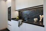 Kitchen, Engineered Quartz Counter, Laminate Cabinet, Range Hood, Porcelain Tile Floor, Wall Oven, Refrigerator, Undermount Sink, and Recessed Lighting  Photo 11 of 27 in An elegant flat where dark tones predominate by Sincro