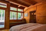 Bedroom, Bench, Light Hardwood Floor, and Bed Main bedroom with walkout porch that wraps around the home and built-in seating. The bedroom faces east for sunrise.  Photo 10 of 15 in The Shirakaba House by Jimi Filipovski