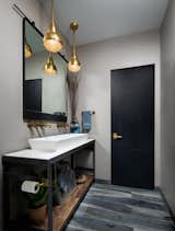 This guest suite off the bedroom features a trough sink with two wall mount faucets, creating a double vanity for a smaller space. We repurposed a console table to mount the vessel sink to, and used pendant lights and a fun mirror to give this room personality!