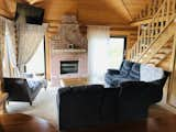 Artisan brick hearth surrounds a Brunner wood-burning stove; vaulted ceiling with hanging television eliminates obstruction of windows