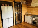 The refrigerator sports four compartments with white glass panels. The pantry waits behind a sliding door built from a black, metal frame and polycarbonate panels. 