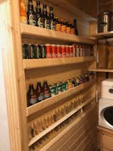 The pantry has custom built shelves in the dividing wall with the fridge. Test tubes with cork caps are used for individual spices. 