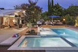 Hot tub complete with tanning ledge and adjacent pool with larger tanning ledge.