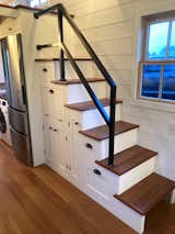 Staircase to loft, fridge, washer dryer, lots of storage. Sturdy custom stair rail. Second step down houses a microwave with a fold down cutting board work area.