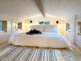 Bedroom, Bed, Wall Lighting, and Light Hardwood Floor Loft with queen size bed and cedar floor.  Photo 8 of 9 in The Roost Roadster by Elizabeth Evans