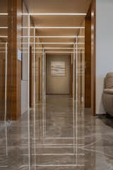 Hallway and Marble Floor The passage leading to all the bedrooms is a prominent feature of the apartment. It is an abstract illumined installation of reflection of light and material. The continuation of led profile light from ceiling to walls gives a playful effect with a sense of illusion.  Photo 20 of 33 in 4BHK MAPLE TREE INTERIOR DESIGN BY PRASHANT PARMAR ARCHITECT by Prashant Parmar Architect - Shayona Consultant