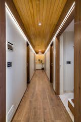 The passage leading to the bedrooms highlighted with wooden flooring and wooden ceiling draws the eyes upwards while the profile light illuminates the space.