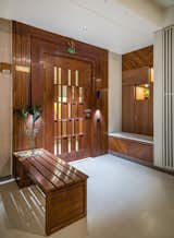 One is greeted by a geometric-decorative panelling that enlivens the vestibule and shields the overall view of the house. A mirrored grid wall with wooden panelling acts as a backdrop to the console unit.
