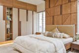 The fresh simplicity of the parents’ bedroom highlights the interesting pattern of veneer and teak wood strips. 
We have created interesting pattern of veneer and teak wood strips the parents’ bedroom.  
We have provided slit windows on the south face to cut the heat in the parents’ bedroom.
