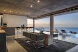 Dining Room, Chair, Ceiling Lighting, Rug Floor, Recessed Lighting, Table, and Concrete Floor Main Kitchen & Dining Area with views over the Atlantic Ocean  Photo 2 of 14 in Fresnaye Pool Penthouse by Jenny Mills Architecture & Interiors
