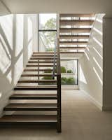 The open stair adjacent a floor to ceiling window brings an abundance of natural light into the home. 