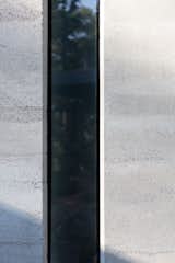 The primary bedroom features narrow frosted glazing in the corners of the room, allowing diffused natural daylight to rake the walls during the day. 