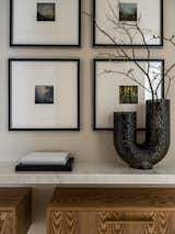 Fragment of the hall. Atmospheric photographs in frames with a large mat. Vase AYTM.