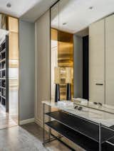 In the hallway designer  framed the openings with brass portals. To divide a long corridor into zones. In There is a Tomasella wardrobe, a Bontempi Casa console, a Gubi ottoman, a Nuura wall lamp.