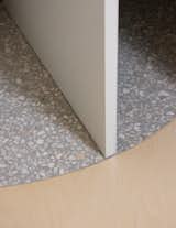 Birch plywood flooring with terrazzo tiles inlay in the shape of door swings