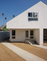 This left-handed cantilever and open garage give emphasis to the upper triangular gable