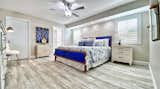 Bedroom, Ceiling Lighting, Night Stands, Light Hardwood Floor, Lamps, Chair, Bed, Dresser, and Storage The master bedroom offers space and relaxation after a beach day.  Photo 2 of 28 in Pipers Run 2 by Jeff Paglialonga