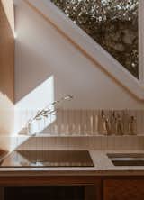 A detail shot of the kitchenette reveals how light from the kitchen skylight rakes across the space in a dramatic effect, casting an interplay of geometric shapes 